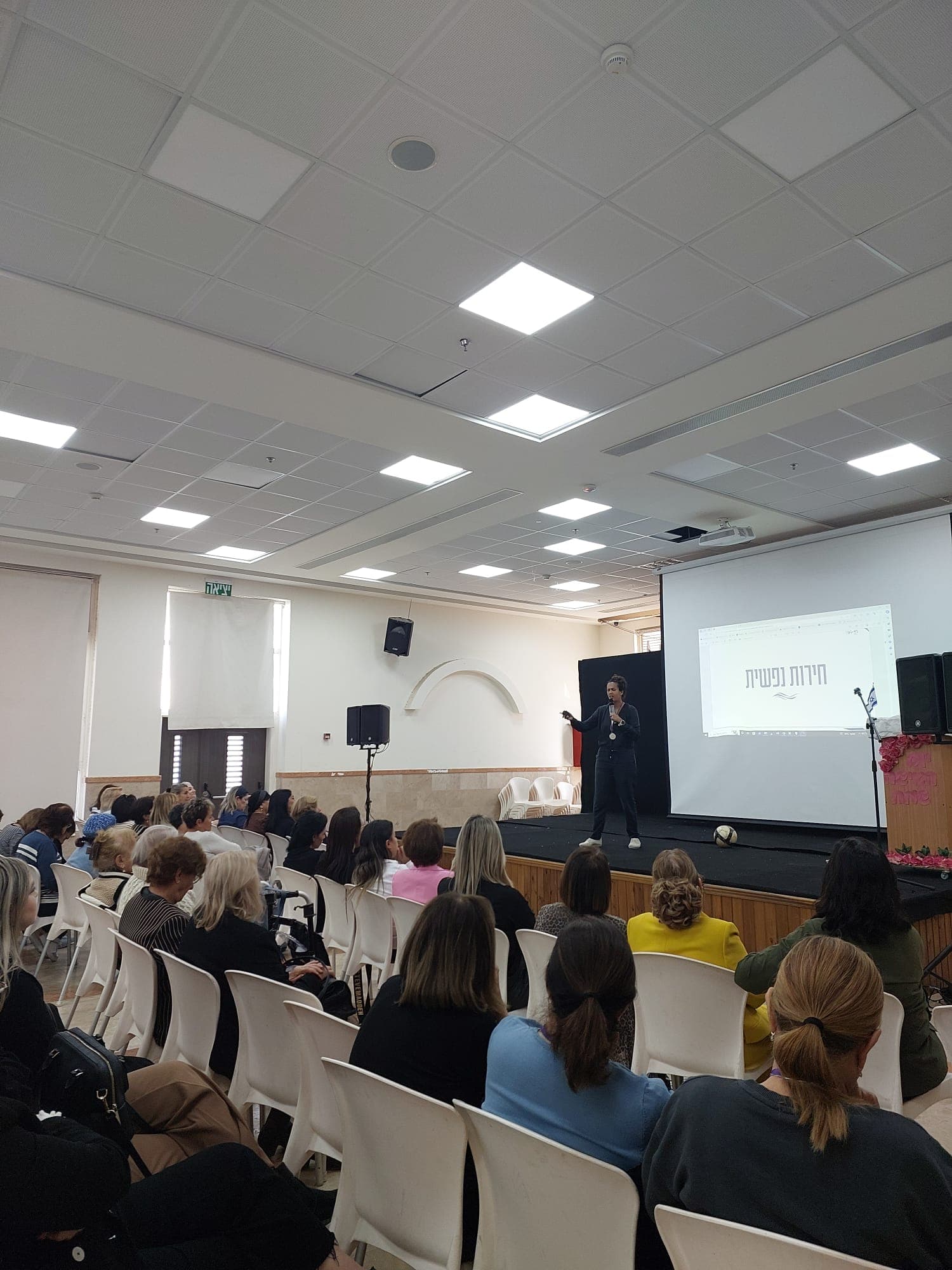 יונה מרצה מול קהל — הרצאת הכי יפה לך מדויקת